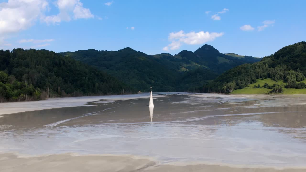 루마니아의 푸른 산이 보이는 범람한 게아마나 마을의 교회 첨탑 꼭대기에서 교차