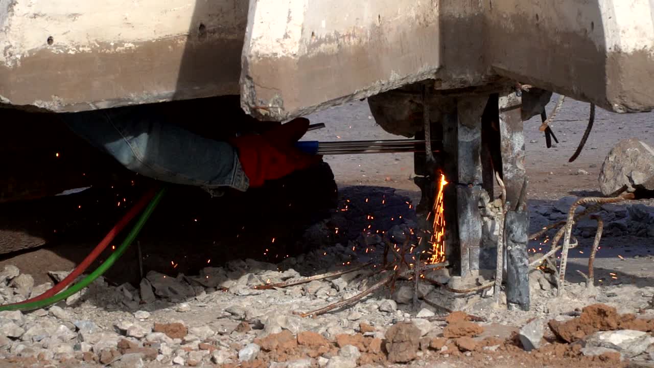 강철 조각을 절단하는 용접기에 의해 생성된 스파크의 핸드헬드, 슬로우 모션 닫기 보기