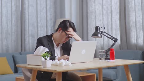 man with headache at home office