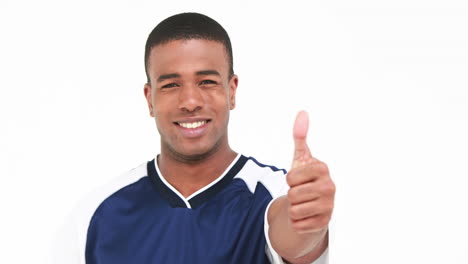 Smiling-volleyball-player-holding-ball-and-showing-thumb-up