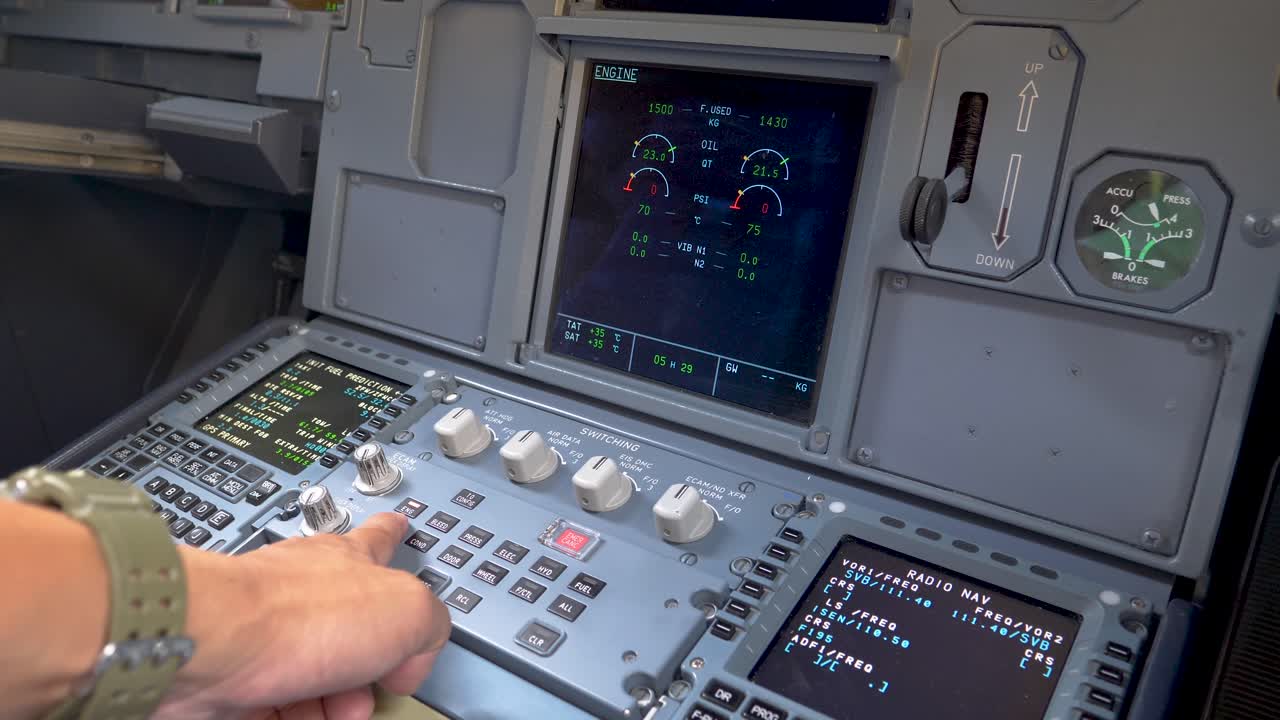 Pilot hand pushing buttons for checking the aircraft status