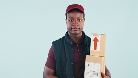 Delivery-man,-boxes-and-thumbs-up-in-studio