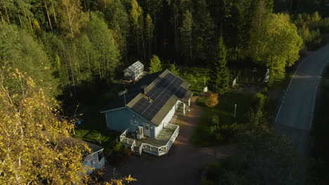 aerial view tilting toward a solar powered house, sunny, autumn evening