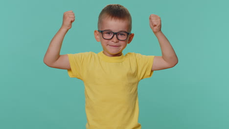 sporty toddler children boy showing biceps and looking confident, feeling power strength success win