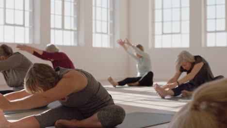 clase de yoga de una mujer madura sana practicando la pose de flexión hacia adelante de la cabeza a la rodilla disfrutando del entrenamiento físico matutino en el estudio