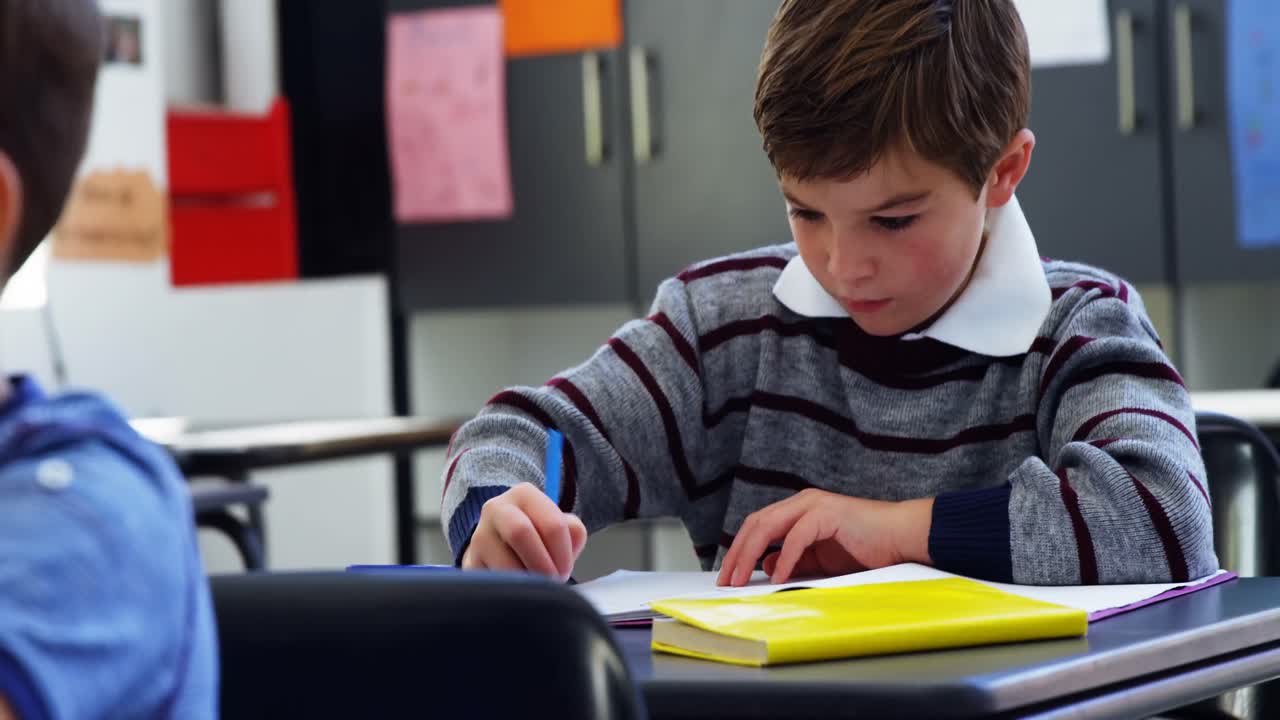 Attentive schoolkids doing their homework in classroom | Premium Stock ...