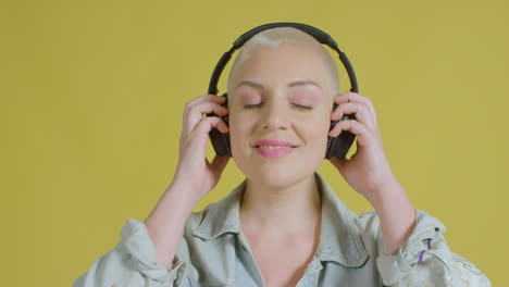 female caucasian model listening to music on headphones studio portrait 06