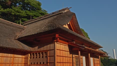 the beautiful thatched roof and wooden facade of a historic japanese building, bathed in warm sunlight. serene traditional view.