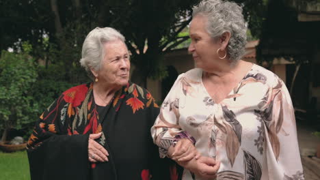 senior sisters walking in park