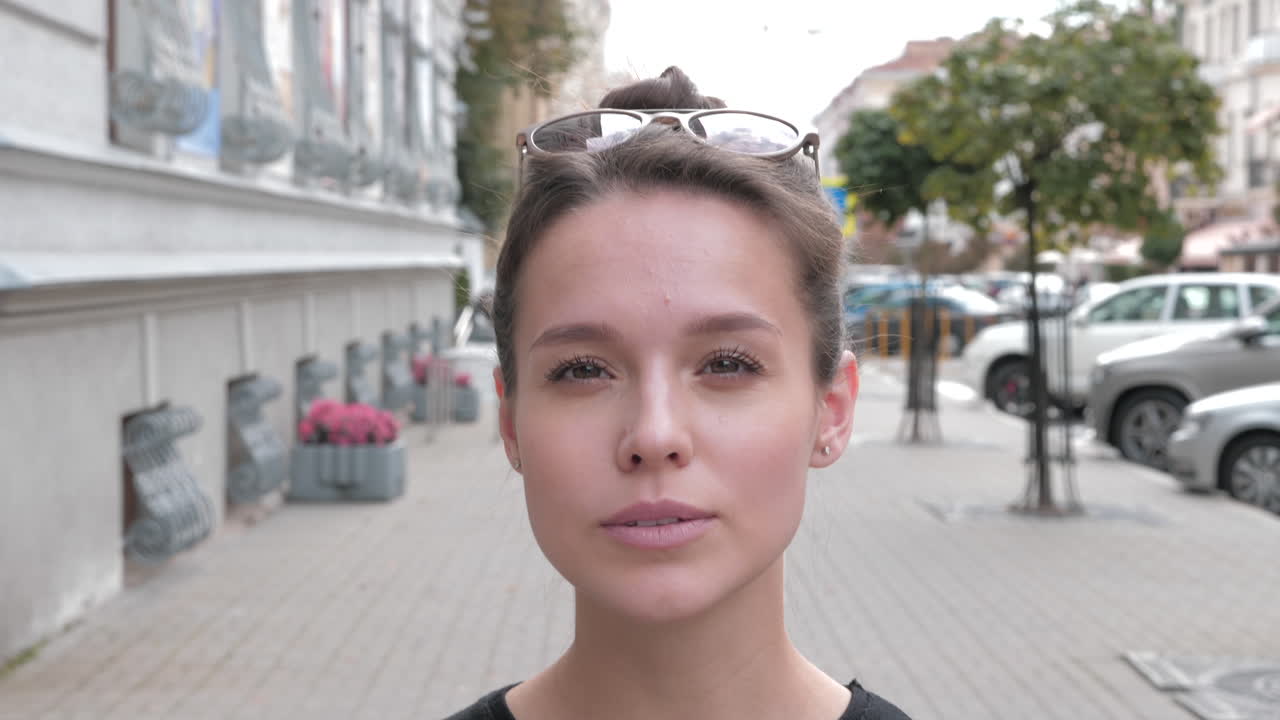 una joven sonriente en la calle.