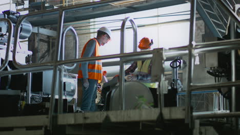 factory workers inspecting machinery