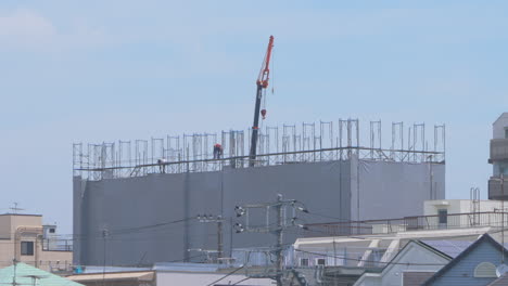 Crane-And-Workers-Installing-Scaffoldings-On-A-Building-Under-Construction