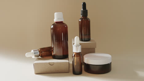 Close-up-of-glass-bottles-and-cardboard-boxes-with-copy-space-on-brown-background