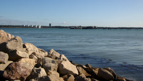 wide shot of rocks and stones on the sea defence at hythe marina village with weston in background