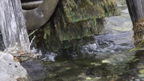 Closeup-of-the-mill-wheel-rotatating-on-top-of-a-stream-of-water