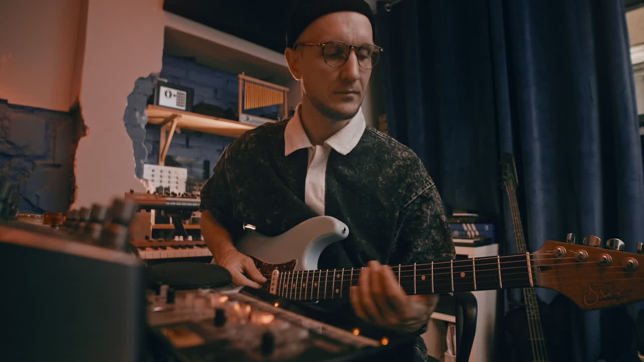 Musician playing guitar in a recording studio
