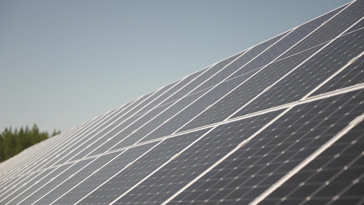 Messa a fuoco selettiva su pannelli solari in un vasto impianto solare, che riflettono la luce del sole, energia pulita ed efficiente, sottile effetto statico con spazio per il testo.