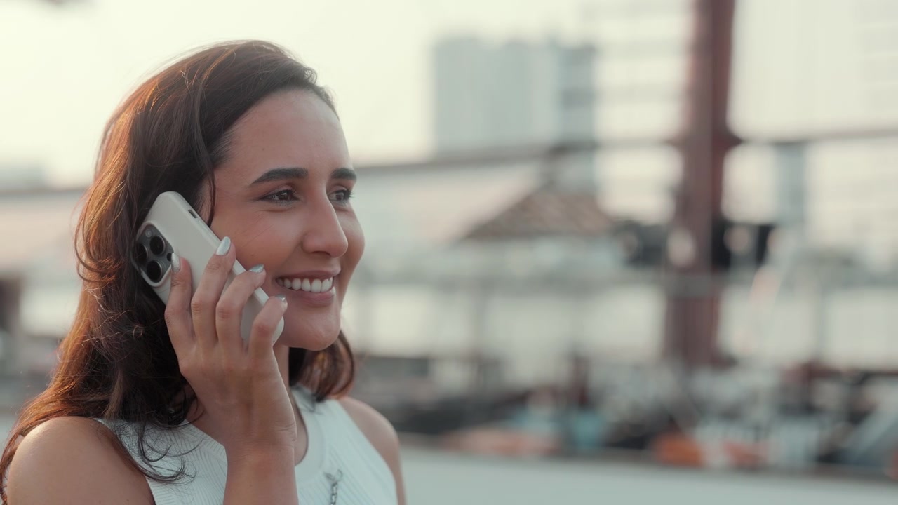Jovem Mulher Sorrindo e Falando ao Telefone Celular ao Ar Livre
