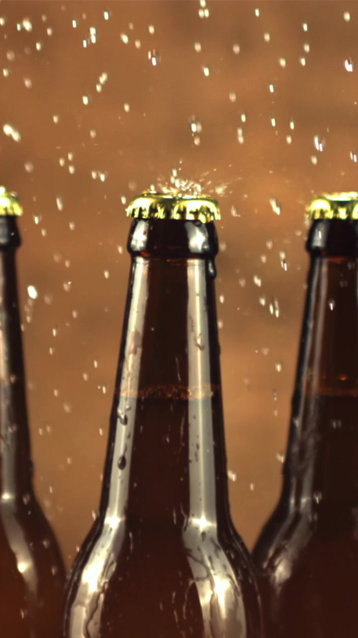 Agua salpicando botellas de cerveza fría en cámara lenta