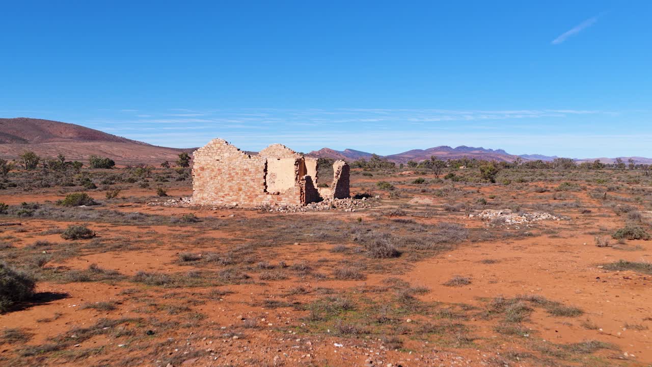 Wide drone shot approaching old stone settler ruin in Flinders Ranges outback