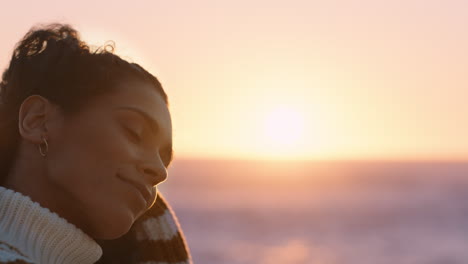 portrait of beautiful hispanic woman enjoying peaceful seaside at sunset exploring mindfulness contemplating spirituality with wind blowing hair