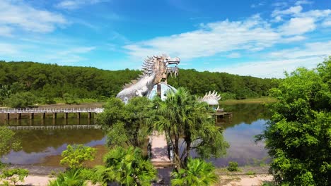 Tiro-Inclinado-Hacia-Arriba-Del-Parque-Acuático-Abandonado-Ho-Thuy-Tien-Con-Una-Enorme-Estructura-De-Dragón-Y-Un-Lago-Vacío-En-Hue,-Vietnam_drone-View