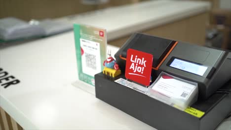 cashier recording sales data on notebook with thermal receipt printer at service counter