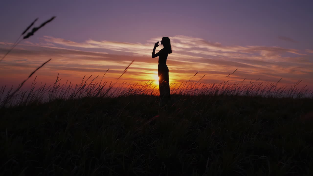 Una mujer meditando al atardecer.