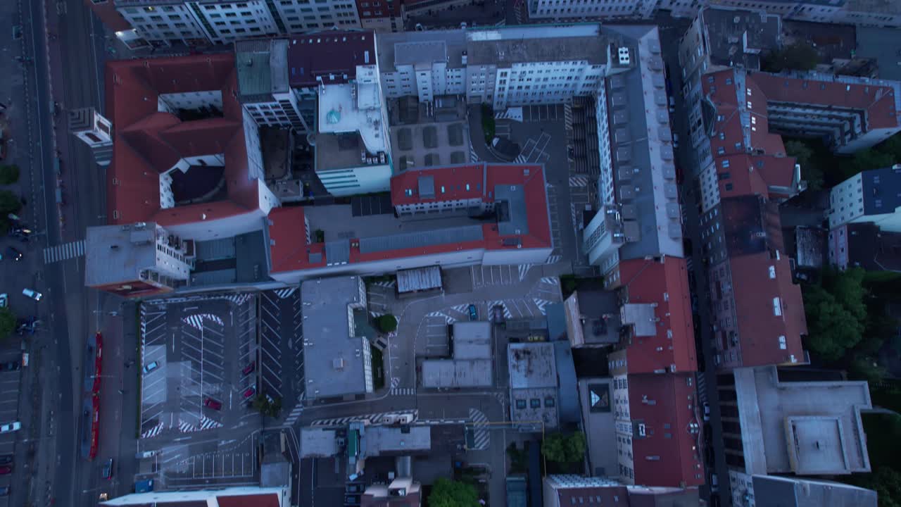Top down aerial of Bratislava streets rooftops, tilt up reveals striking townscape at blue hour
