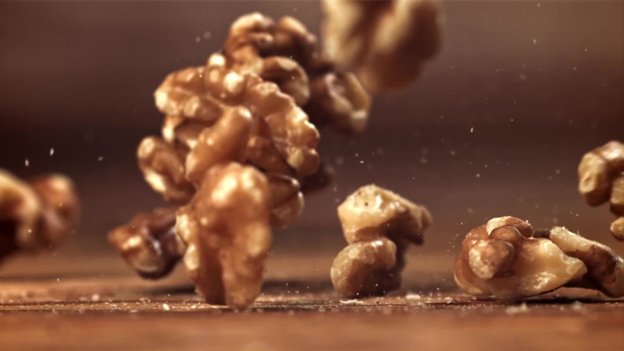 Walnuts Falling onto a Wooden Surface in Slow Motion