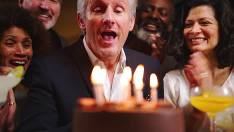 grupo de amigos de mediana edad celebrando su cumpleaños en un bar