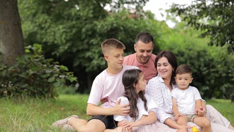 happy family with children on a picnic outdoors on a summer day love picnic and family time happy family with children on a picnic outdoors on a summer day a family with children is enjoying a picnic in a spring garden happy young family smiling and relaxing in the park chatting and having fun