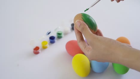 pintar a mano huevos de pascua coloridos sobre un fondo blanco. decoración de alimentos en vacaciones. estilo de vida de la gente.