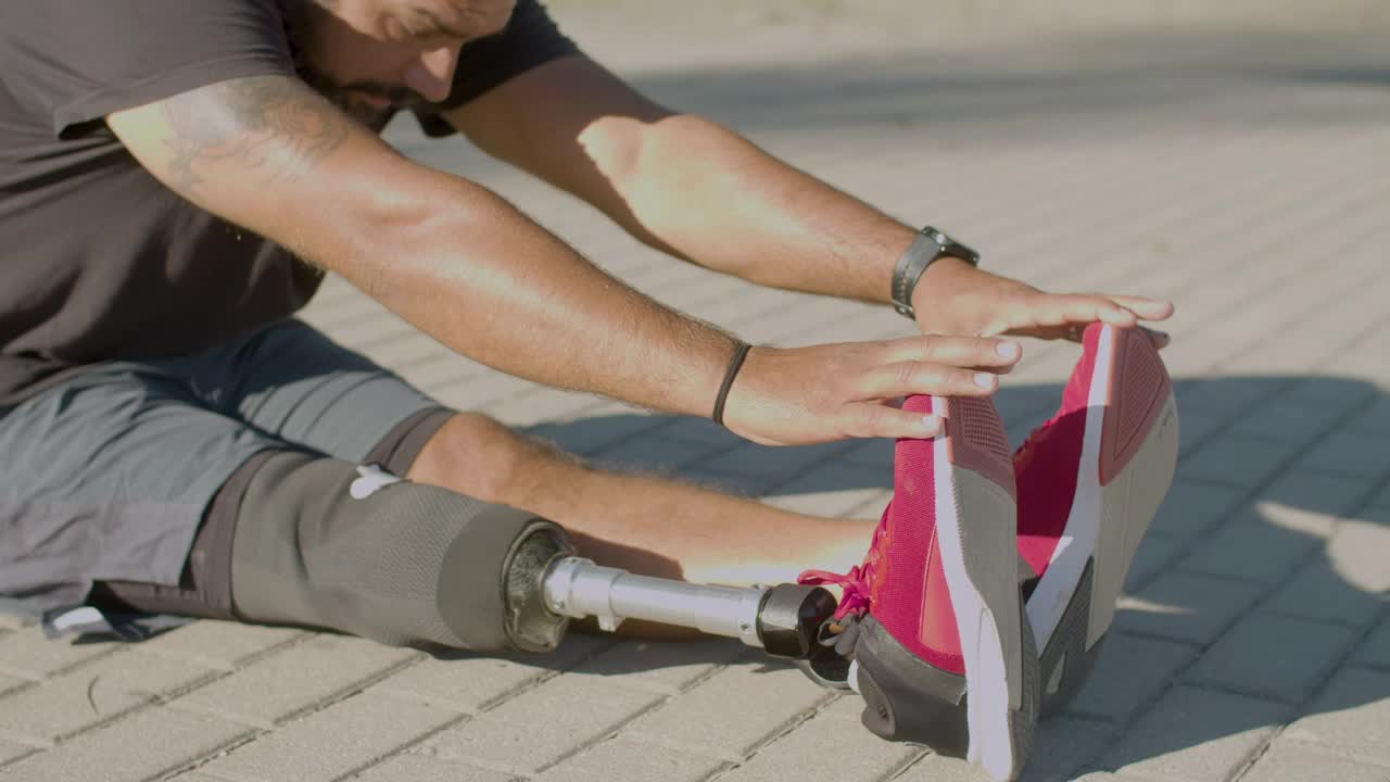 vista lateral de un hombre con prótesis haciendo ejercicios de estiramiento