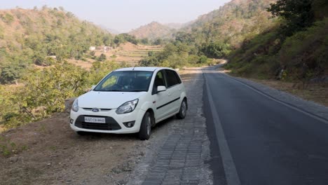 white ford figo parked on a mountain road in india