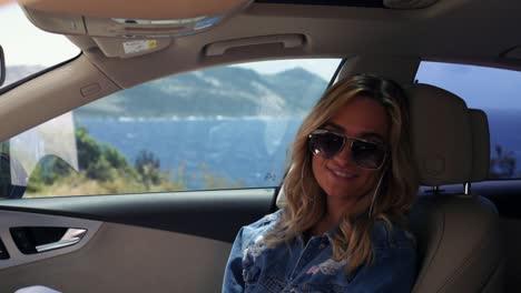 mujer sentada en el auto está mirando a la cámara y sonriendo