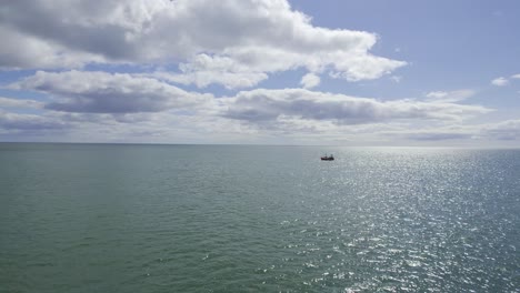 approaching a fishing boat off the Waterford Coast flying close to the sea on a warm summer morning brightblus sky and shimmering seas