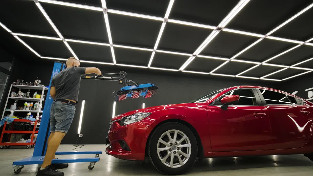 las lámparas rojas para el secado del revestimiento cerámico están detrás del coche
