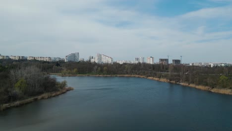 Descending-drone-shot-of-Chișinău-City-Gates-in-Moldova-in-spring-2023-with-lake-in-the-foreground---Chisinau-Bulevardul-Dacia---Aerial-4k-panorama-bird-view