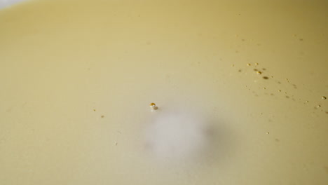 Golden-jojoba-oil-spreads-into-puddle-leaving-white-circle