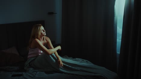 woman sitting in bed at night