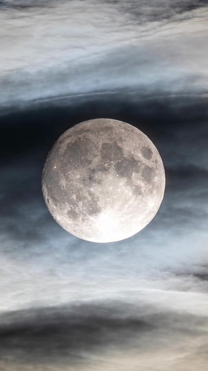 Vídeo vertical: Vento empurrando nuvens finas sobre a lua centralizada em enquadramento vertical, mostrando crateras.