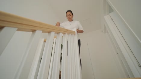 a beautiful pregnant woman tidying her home, engaged in household chores. the scene captures domestic life, maternity, and the balance of routine and preparation during pregnancy