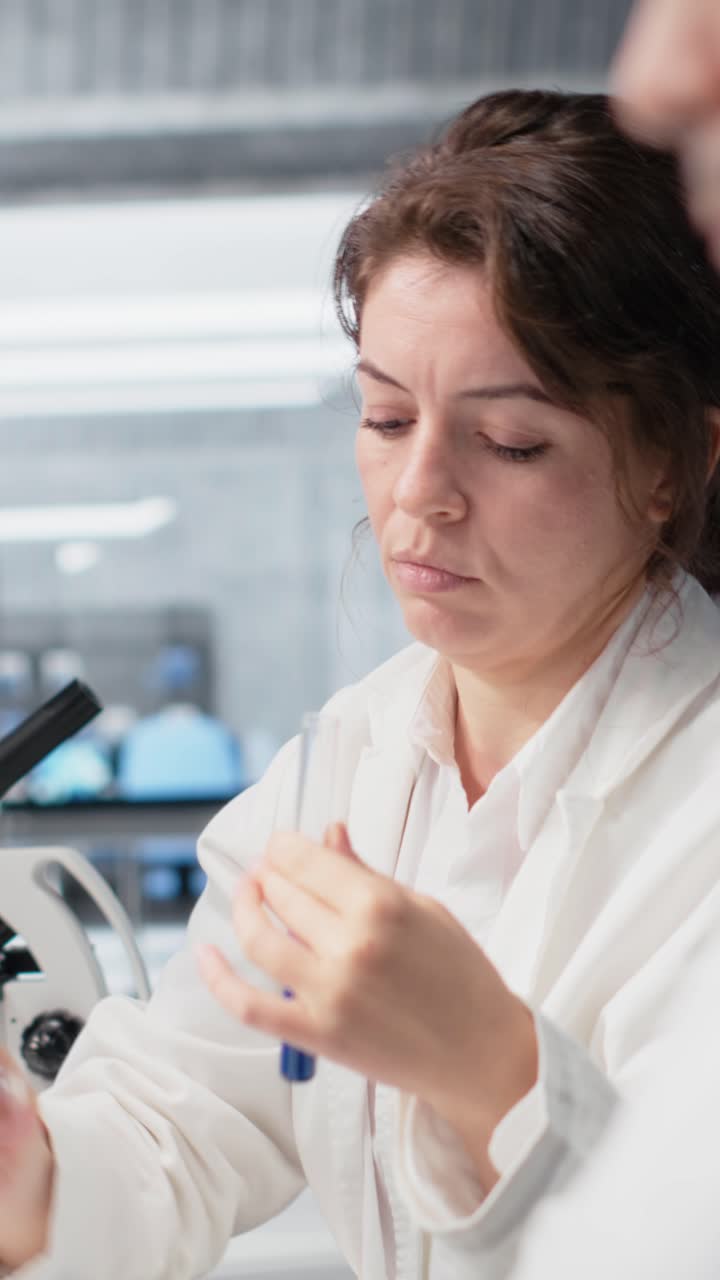 Vertical video Laboratory chemist investigates chemical behavior of liquid sample in test tube