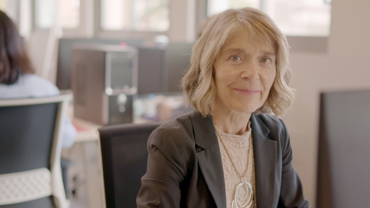 Woman working with computer and smiling in a coworking desk