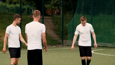 groupe de jeunes footballeurs s'entraînant et se passant le ballon sur un terrain de football de rue par une journée ensoleillée 6