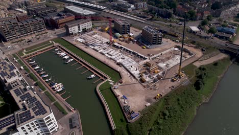 aerial rotating pan showing construction site of luxury apartment kade zuid complex being build in former industrial area