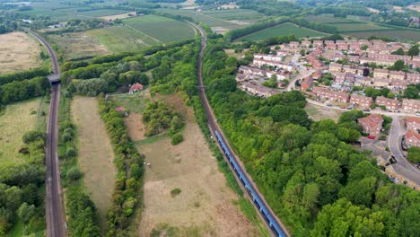 arial shot of a train going passed houses and heading away from canterbury and towards the a2 dual carriageway