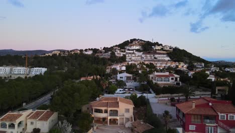 drone footage of houses with swimming pools and relaxed community lifestyle from calpe, spain on a warm evening