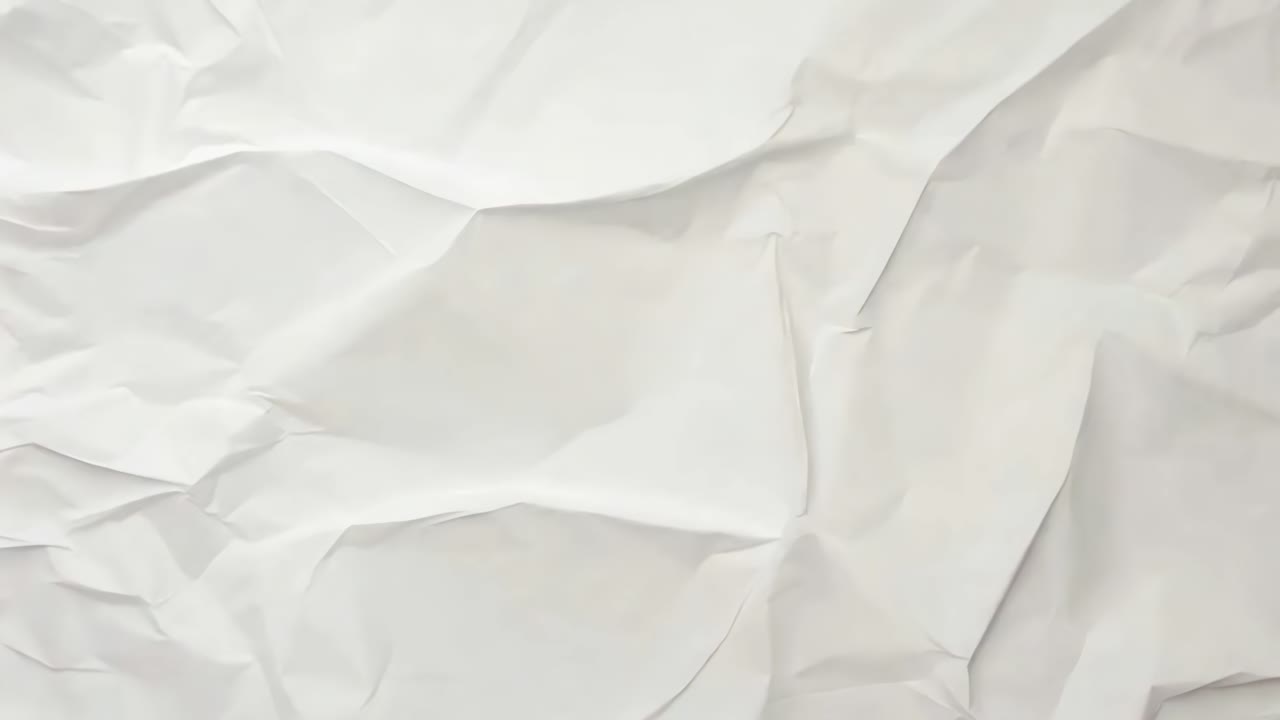 Crumpled white paper texture viewed from above, creating a minimalist, abstract background ideal